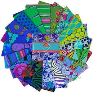 May include: A circular arrangement of patterned fabric squares in vibrant colours. The fabrics display floral, geometric, and abstract designs in blue, green, purple, and pink hues. A rectangular box with text is positioned in the centre.