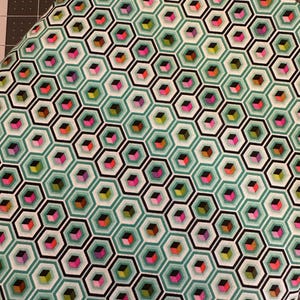May include: A fabric featuring a repeating geometric pattern of black-outlined hexagons in shades of teal and white. Inside each hexagon is a small three-dimensional cube rendered in vibrant colors including pink, orange, yellow, and purple.