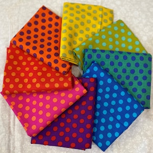 Puede incluir: Una colección de cuadrados de tela doblados en varios colores, cada uno adornado con un patrón de lunares. Los colores incluyen naranja, rojo, rosa, morado, azul, verde y amarillo. La tela está dispuesta en un patrón circular, mostrando la variedad de tonos.