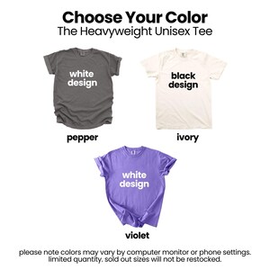 three different t-shirt designs, each with a different color: white, black, and purple. The text above the images reads "Choose Your Color The Heavyweight Unisex T-shirt" and below the images, it says "Please note colors may vary by computer monitor or phone settings. Limited quantity, sold out sizes will not be restocked."