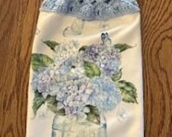 Hanging kitchen towel with a crocheted top.  It has hydrangeas in a container on white back ground. Microfiber material.  Is soft