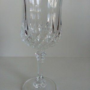 Peut inclure: Un verre à vin en verre transparent avec un motif en forme de diamant. Le verre a une longue tige et une base large.