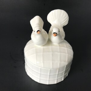 May include: White ceramic trinket box with two white doves on top. The box has a chequered pattern.