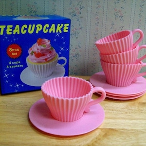 May include: A set of pink silicone teacup cupcake molds. The set includes four cups and four saucers. The box says "Teacupcake 8PCS Set 4 cups 4 saucers".