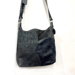 Crossbody aus punziertem Leder in schwarz, Leder mit Boheme-Prägung, Schnürung, verstellbarer Riemen, Hardware- und Futteroptionen, Reißverschlusstasche außen