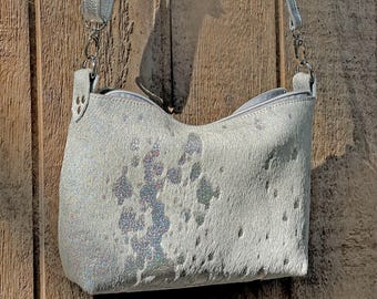 Bolso bandolera de piel de vacuno holográfica con efecto desteñido a mano, correa ajustable extraíble, cremallera y bolsillos interiores.