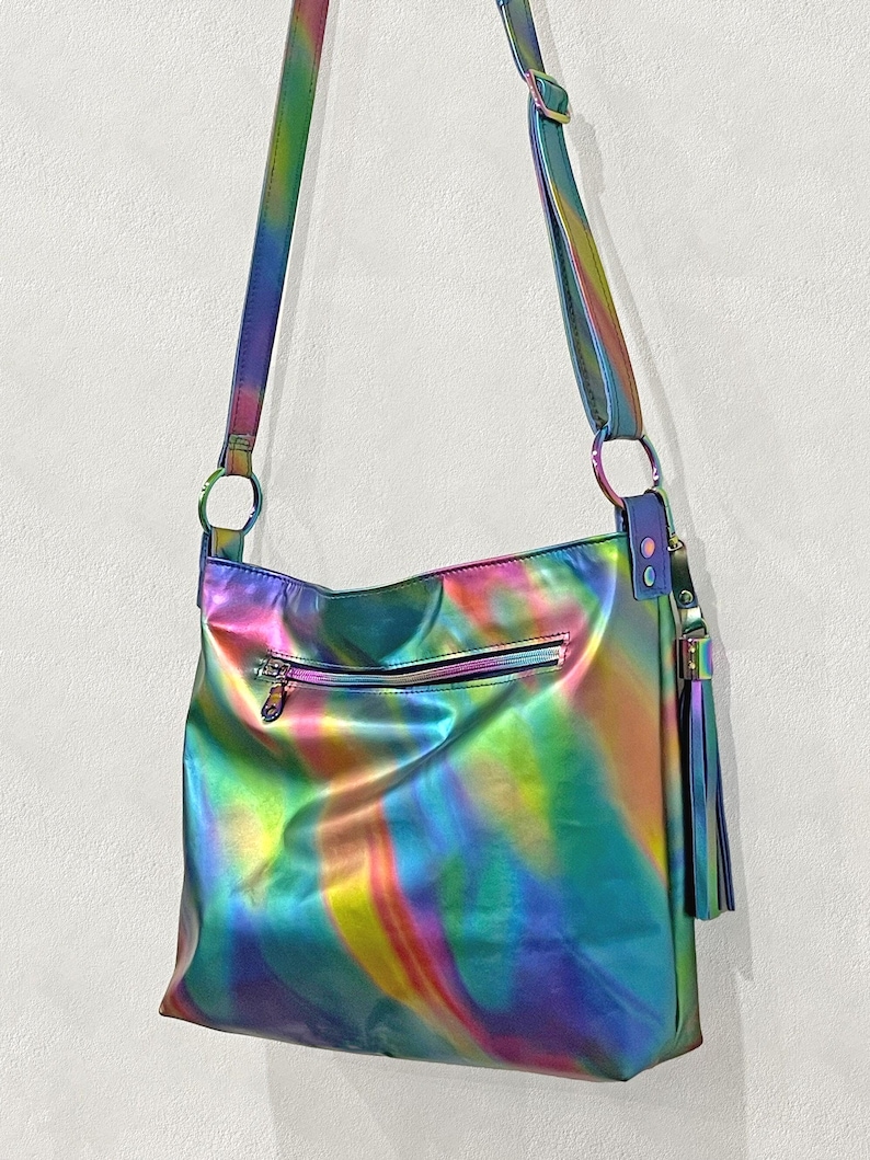 Aurora colourful bright spectral leather bag with outside soft glide zipper pocket and inside slip pockets. Leather tassel clip on, adjustable comfortable leather strap