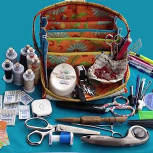 May include: A colorful fabric sewing kit with multiple compartments, filled with sewing supplies including spools of thread, needles, scissors, and a rotary cutter.