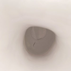 K&ouml;nnte beinhalten: Nahaufnahme einer wei&szlig;en Toilettensch&uuml;ssel mit einem kleinen Riss im Porzellan.
