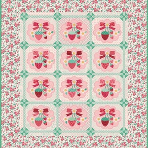 Puede incluir: Un edredón de retazos cuadrado con un patrón repetitivo de fresas y lazos sobre un fondo rosa. El edredón tiene un borde floral en tonos rosas y verdes. El diseño es simétrico.