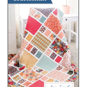 May include: A colorful patchwork quilt with a variety of floral and geometric patterns in red, orange, yellow, and blue. The quilt features the text "Craftsman" and "Amy Smart - Diary of a Quilter".