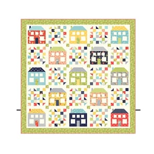 May include: A colorful quilt featuring a repeating pattern of houses in various colors, including red, yellow, blue, and green. The houses are set against a white background with patchwork squares. The quilt is bordered with a green floral pattern.