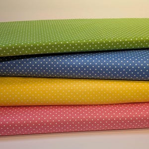Peut inclure: Quatre échantillons de tissu avec des pois blancs sur des fonds de couleurs différentes. Les échantillons sont empilés les uns sur les autres, avec l'échantillon vert sur le dessus, suivi du bleu, du jaune et du rose.