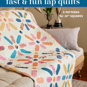 May include: A book titled "fast & fun lap quilts" with a colorful quilt on a couch. The book cover features 9 patterns for 10" squares.