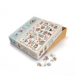 May include: A Jane Austen A to Z 250-piece puzzle. The puzzle box is light blue and white, with illustrations of Jane Austen-themed imagery. Some puzzle pieces are scattered around the box. The box is open, revealing the puzzle pieces inside.