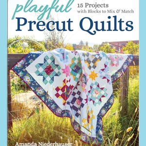 Peut inclure: Couverture de livre "Playful Precut Quilts" avec une courtepointe colorée ornée d'étoiles et de blocs, drapée sur une clôture en bois. La couverture affiche également le nom de l'auteur, Amanda Niederhauser, et le titre du livre.