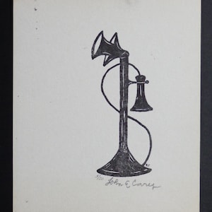 Puede incluir: Grabado en madera en blanco y negro de un teléfono de disco antiguo. La impresión está firmada "John E. Carey" y numerada "5/20".