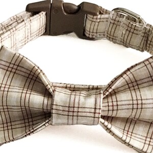 May include: A beige and brown plaid dog collar with a matching bow tie.