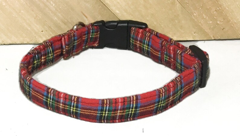 May include: Red and green plaid dog collar with a black plastic buckle.
