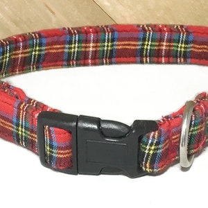 May include: Red and green plaid dog collar with a black plastic buckle and a silver metal D-ring.