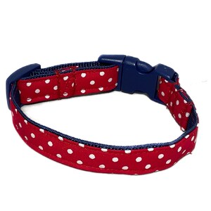 May include: Red and navy blue dog collar with white polka dots. The collar has a plastic buckle.