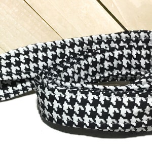 May include: Black and white houndstooth patterned fabric ribbon.