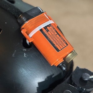 Può includere: Marcatore di luce di soccorso arancione e nero con il numero di modello RS SDU-SIE, il numero di serie 038456, il NSN 6230-00-938-1778 e la scritta "LIGHT MARKER, DISTRESS" stampata sul lato.