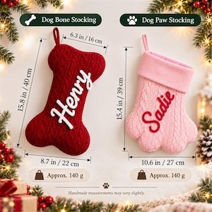 May include: A red cable-knit dog bone stocking labeled Henry and a pink cable-knit dog paw stocking labeled Sadie. The bone measures 15.8 inches by 8.7 inches, and the paw measures 15.4 inches by 10.6 inches. Both weigh 140 grams.