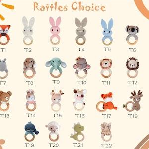 May include: A collection of twenty-two crochet baby rattles in various animal shapes, including a fox, rabbit, koala, and lion. Each rattle features a wooden ring and is labeled with a "T" followed by a number.