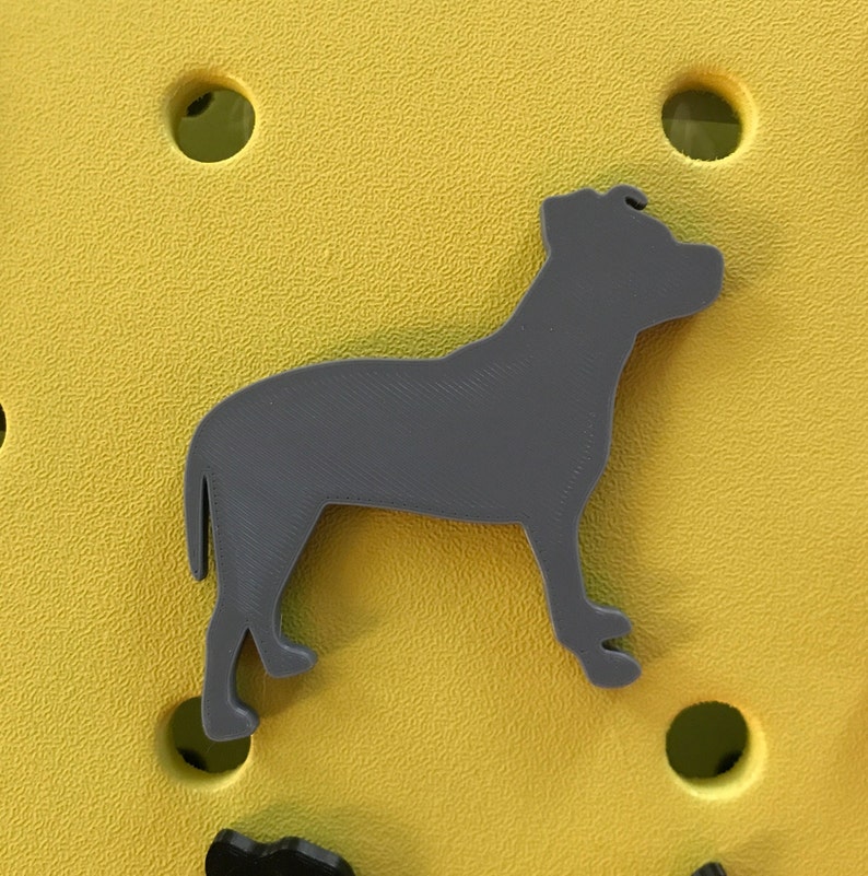 May include: A gray silhouette of a dog standing on a yellow background.