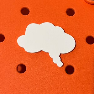 May include: White cloud-shaped charm with a thought bubble tail, on an orange background.