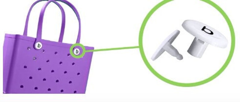 May include: Purple tote bag with a polka dot pattern and two white buttons labeled "b". The bag has two handles. A close-up of the buttons shows a white button with the letter "b" in black.