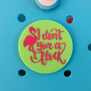 May include: A green circle with a pink flamingo and the text "I don't give a flock" in pink.