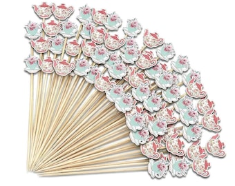 May include: A collection of decorative wooden skewers with paper cutouts. The cutouts feature a teapot and teacup design with pink roses and a light blue background. The skewers are made of natural wood.