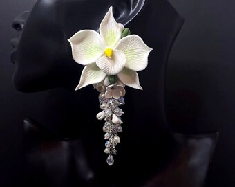 Pendientes de arcilla polimérica con orquídea blanca y cristales colgantes, joyería floral hecha a mano.