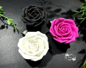 Peut inclure: Trois roses en argile polymère, une noire, une blanche et une rose. Chaque rose a une boucle argentée attachée à l'arrière pour la suspension.
