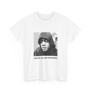 May include: White t-shirt with a black and white graphic of a person in a hooded top. The text "THEY'RE ALL BAD DEFENDERS" is printed below the image. The shirt is made of a soft material and is suitable for casual wear.