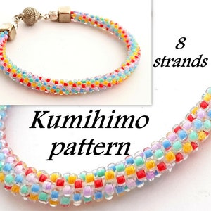 Könnte beinhalten: Ein farbenfrohes Perlenarmband, hergestellt mit einem Kumihimo-Muster. Das Armband besteht aus 8 Perlensträngen und hat einen silbernen Verschluss.