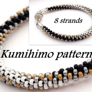May include: A black, white, gold, and silver beaded bracelet with a magnetic clasp. The bracelet is made with 8 strands of beads and is a Kumihimo pattern.