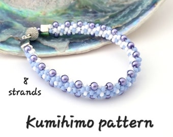 May include: A close-up of a light blue, white, and purple beaded bracelet made with the kumihimo braiding technique. The bracelet is made with 8 strands of beads and has a silver clasp. The text "8 strands" and "Kumihimo pattern" is visible in the image.