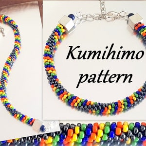 May include: A colorful beaded bracelet with black, green, yellow, orange, and blue beads. The bracelet is made using a Kumihimo pattern and has silver clasps on each end. The bracelet is on a reflective surface and the text "Kumihimo pattern" is visible in the image.