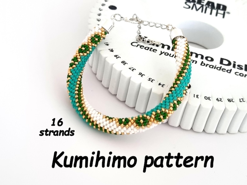 May include: A green, white, and gold kumihimo bracelet with 16 strands. The bracelet is on a white kumihimo disc with numbers and the words "Create your own braided cord".