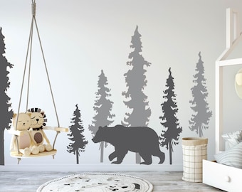 May include: A nursery room with a white crib and a swing hanging from the ceiling. The wall is decorated with a gray bear silhouette and a forest scene with gray trees.