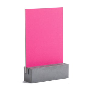 May include: A gray concrete stand with a slot to hold a bright pink card or sign. The stand is a simple, modern design.