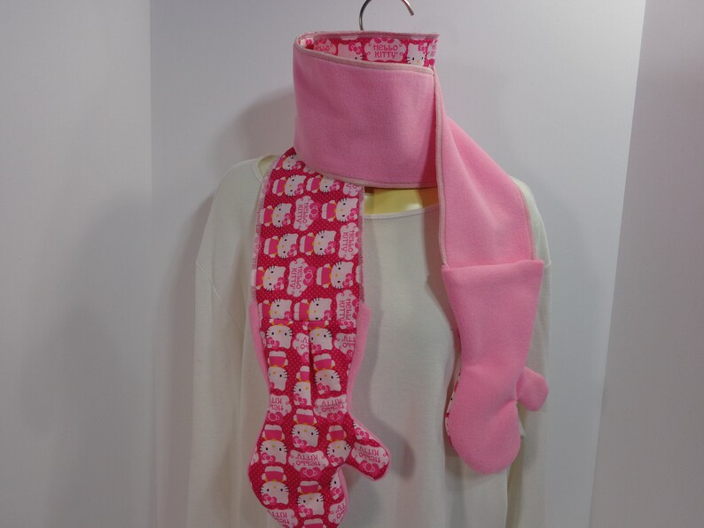 Each scarf has a mitten attached to each end of the scarf These scarfmittens set come as a one piece item creating a one piece garment.