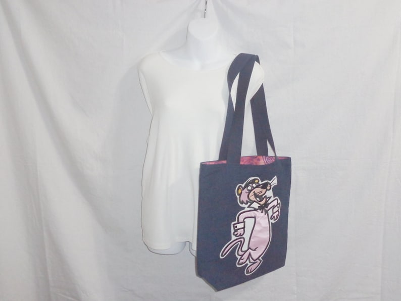 This Snagglepuss tote has shoulder straps and inside pockets This large tote is very stylish and goes well with a variety of outfits.
