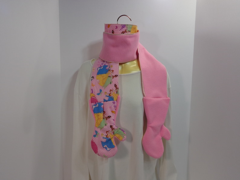 Each scarf has a mitten attached to each end of the scarf These scarfmittens set come as a one piece item creating a one piece garment.