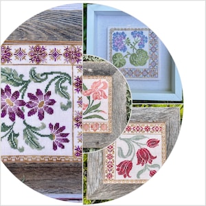 Op de afbeelding: Vier ingelijste kruissteekborduurwerken met bloemmotieven. De ontwerpen omvatten een ​​paarse bloem met groene bladeren, een roze bloem met groene bladeren, een rode bloem met groene bladeren en een blauwe bloem met groene bladeren.