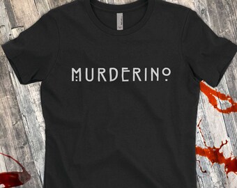 Op de afbeelding: Zwart T-shirt met het woord "Murderino" in wit op de voorkant.