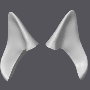 Könnte beinhalten: Ein Paar weiße, im 3D-Druck hergestellte, spitze Ohren. Die Ohren sind so konzipiert, dass sie wie Tierohren aussehen.